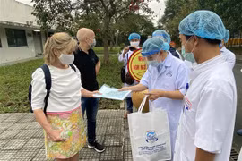 Lãnh đạo Bệnh viện Trung ương Huế trao giấy xác nhận y tế khỏi bệnh cho nữ bệnh nhân số 30. (Ảnh: Mai Trang/TTXVN)