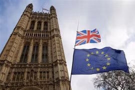 Quốc kỳ Anh (phía trên) và cờ Liên minh châu Âu (phía dưới) bên ngoài tòa nhà Quốc hội Anh ở London. (Ảnh: THX/TTXVN)