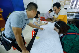 Người dân thôn Hữu Thanh Oai, xã Hữu Hòa, huyện Thanh Trì kiểm tra, đối chiếu số liệu, thông tin đất đai trên bản đồ tại điểm làm thủ tục kiểm kê đất đai và lập bản đồ hiện trạng sử dụng đất. (Ảnh: Trọng Đạt/TTXVN)