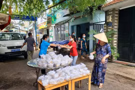 Đại diện Liên đoàn Lao động quận Gò Vấp trao Suất ăn nghĩa tình Công đoàn Gò Vấp cho công nhân ở trọ, người nghèo trong khu phong tỏa. (Ảnh: Thanh Vũ/TTXVN)