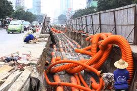 Thi công hạ ngầm tuyến cáp trên đường Lê Văn Lương. (Ảnh: Hồng Kỳ/TTXVN) 