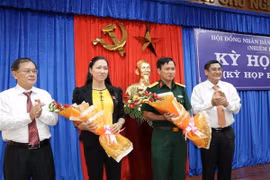 Tặng hoa chúc mừng đại biểu được bầu làm Phó Chủ tịch Hội đồng Nhân dân và Ủy viên Ủy ban. (Ảnh: Công Trí/TTXVN)