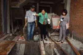 Cán bộ y tế phường Phú Thạnh, quận Tân Phú rải thuốc diệt loăng quăng tại một công trình xây dựng. (Ảnh: Phương Vy/TTXVN)