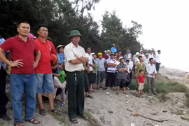 Người thân, thầy cô, bạn bè và người dân tại hiện trường vụ đuối nước thương tâm. (Ảnh: Văn Đạt/TTXVN)