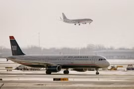 Máy bay của American Airlines bay qua máy bay của US Airways tại sân bay O'Hare ở Chicago, Illinois. (Nguồn: AFP/TTXVN)