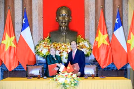 Chủ tịch nước Trần Đại Quang và Tổng thống nước Cộng hòa Chile Michelle Bachelet Jeria ký Tuyên bố chung. (Ảnh: Nhan Sáng/TTXVN)