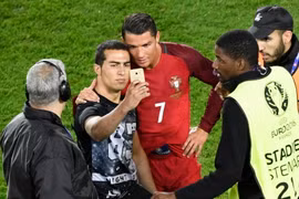 Ronaldo cố gắng cười khi chụp ảnh cùng người hâm mộ. (Nguồn: AFP/Getty Images)