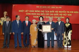 Chủ tịch Quốc hội Nguyễn Thị Kim Ngân tặng bức tranh cho bà con Việt kiều. (Ảnh: Trọng Đức/TTXVN)