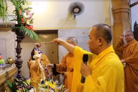 Thượng tọa Thích Hạnh Chánh cử hành nghi lễ tắm Phật. (Ảnh: Huy Bình/Vietnam+)
