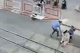 Cụ bà vấp ngã và được nhân viên gác chắn dũng cảm kéo ra khỏi đường ray đúng lúc đoàn tàu lao tới. (Ảnh: Trích từ camera an ninh)