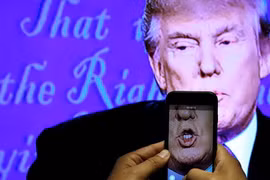 Một nhà báo ghi lại hình ảnh ông Donald Trump trong cuộc tranh luận với bà Hillary. (Nguồn: Reuters)