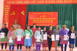 Lãnh đạo Bộ Tư pháp trao quyết định nhập quốc tịch Việt Nam cho các công dân Lào. (Ảnh: Hữu Quyết/TTXVN)