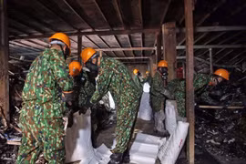 Lực lượng Binh chủng Hóa học thu gom chất thải, giải phóng hiện trường để tiến hành tẩy độc mặt nền nhà xưởng. (Ảnh: Dương Giang/TTXVN)