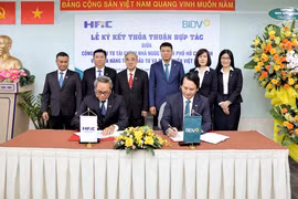 Ông Nguyễn Quang Thanh (Phó Tổng Giám đốc HFiC) và ông Trần Long (Phó Tổng Giám đốc BIDV) đại diện hai đơn vị ký kết thỏa thuận hợp tác. (Ảnh: Vietnam+)