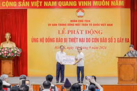 Phó Thống đốc Thường trực Đào Minh Tú trao ủng hộ của ngành Ngân hàng. (Ảnh: Vietnam+)