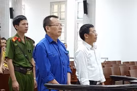 Bị cáo Nguyễn Văn Tuẫn (áo xanh dương) và bị cáo Bùi Mạnh Hà (áo trắng) đứng trước vành móng ngựa. (Ảnh: Kim Anh/TTXVN)