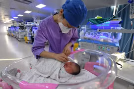 Y tá chăm sóc một đứa trẻ sơ sinh ở bệnh viện nhi tại tỉnh An Huy, Trung Quốc ngày 17/1/2024. (Ảnh: AP)