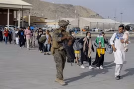Binh sỹ Mỹ hỗ trợ người dân sơ tán khỏi Afghanistan, tại sân bay quốc tế Hamid Karzai ở Kabul ngày 18/8/2021. (Ảnh: AFP/TTXVN)