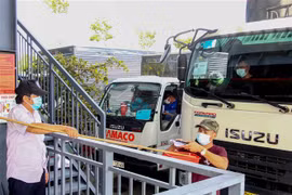 Tài xế trình giấy tờ tại chốt kiểm soát trong Bến xe trung tâm thành phố Cần Thơ để được vào thành phố giao nhận hàng hóa. (Ảnh: Thanh Liêm/TTXVN)