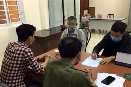 Em N.H.L (áo đen) khai nhận sự việc tại cơ quan công an. (Ảnh TTXVN phát)