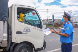 Lực lượng Thanh tra giao thông kiểm tra giấy tờ của một xe tải chờ hàng hóa vào thành phố Cần Thơ. (Ảnh: Thanh Liêm/TTXVN)