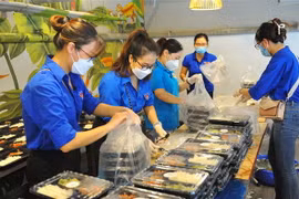 Các đoàn viên thanh niên chuẩn bị các suất cơm để chuyển tới tay những công nhân lao động, sinh viên nghèo, hộ khó khăn và người khuyết tật bị ảnh hưởng bởi dịch bệnh COVID-19. (Ảnh: Minh Đức/TTXVN)