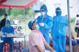 Đội thanh niên tình nguyện thuộc Tỉnh đoàn Bình Dương hỗ trợ ngành y tế lấy mẫu xét nghiệm tại 'vùng đỏ' của 15 phường trên địa bàn thành phố Thuận An, Dĩ An và thị xã Tân Uyên. (Ảnh: Chí Tưởng/TTXVN)