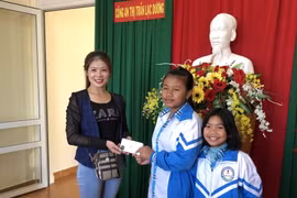 Hai em học sinh lớp 7 trả lại chiếc điện thoại trị giá hơn 10 triệu đồng cho người làm rơi. (Ảnh: TTXVN phát)