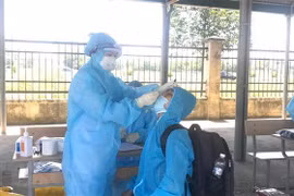 Nhân viên y tế lấy mẫu xét nghiệm cho người dân. (Ảnh: TTXVN)