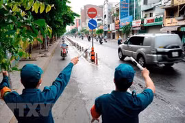 Các lực lượng chức năng hướng dẫn người dân quay đầu xe khi đi vào quận Gò Vấp. (Ảnh: An Hiếu/TTXVN)