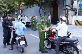 Lực lượng Công an Hà Nội kiểm tra giấy tờ của người tham gia giao thông tại chốt liên ngành tuyến phố Trần Quang Khải (quận Hoàn Kiếm). (Ảnh: Phạm Kiên/TTXVN)