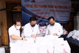 Ông Phùng Công Dũng, Chủ nhiệm Ủy ban về người Việt Nam ở nước ngoài Thành phố Hồ Chí Minh (ngoài cùng bên phải), ông Lê Bá Linh, kiều bào Thái Lan, Chủ tịch Hội đồng quản trị Công ty Cổ phần Pacific Foods (giữa) kiểm tra các phần quà cho người dân nghèo 
