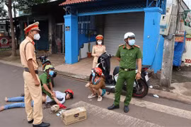 Hai đối tượng bị lực lượng công an bắt giữ cùng tang vật. (Ảnh: Đậu Tất Thành/TTXVN)