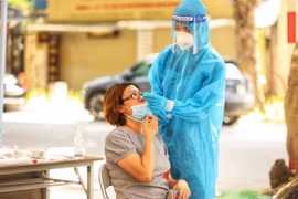 Nhân viên y tế lấy mẫu xét nghiệm COVID-19 cho người dân. (Nguồn: TTXVN)