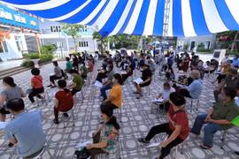 Người dân đến tiêm phải tuân thủ đảm bảo giãn cách an toàn phòng tránh dịch COVID-19. (Ảnh: Phan Tuấn Anh/TTXVN)