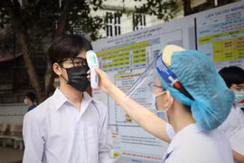 Kiểm tra thân nhiệt các thí sinh dự thi tại điểm thi Trường Trung học phổ thông Ngô Sỹ Liên, Bắc Giang. (Ảnh: Danh Lam/TTXVN)