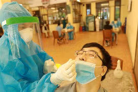 Nhân viên y tế quận Cầu Giấy, Hà Nội lấy mẫu xét nghiệm cho người dân. (Ảnh: Vũ Sinh/TTXVN)