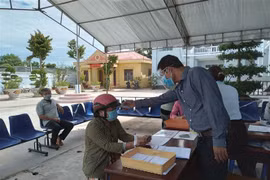 Đo thân nhiệt người bán vé số, người lao động tự do đến nhận hỗ trợ. (Ảnh minh họa. Nguồn: TTXVN)