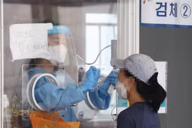 Nhân viên y tế lấy mẫu xét nghiệm COVID-19 cho người dân tại Seoul, Hàn Quốc, ngày 1/8/2021. (Ảnh: Yonhap/TTXVN)