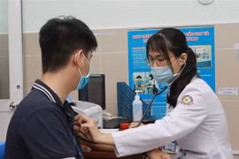 Nhân viên y tế Bệnh viện quận 11, TP.HCM được khám sàng lọc trước khi tiêm vaccine phòng COVID-19. (Ảnh: Đinh Hằng/TTXVN)