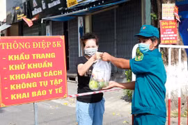 Tiếp tế lương thực cho người dân các khu vực bị phong tỏa. (Ảnh: Lê Ngọc Phước/TTXVN)