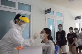 Nhân viên y tế lấy mẫu xét nghiệm cho sinh viên tình nguyện. (Ảnh: Văn Dũng/TTXVN)