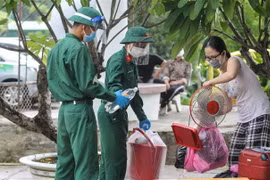 Cán bộ, chiến sỹ Sư đoàn 5, Quân khu 7 cùng các lực lượng chức năng quận Bình Thạnh giúp người dân sống tại các khu trọ, nhà lụp xụp, nhà ven kênh di dời về ở tại Nhà nghỉ Công đoàn Thanh Đa, quận Bình Thạnh để đảm bảo an sinh xã hội và phòng, chống dịch 