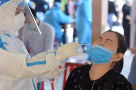 Nhân viên y tế lấy mẫu xét nghiệm COVID-19. (Ảnh: Văn Dũng/TTXVN)