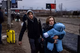 Người dân sơ tán khỏi thành phố Irpin, phía Tây Bắc Kiev, Ukraine ngày 7/3. (Ảnh: AFP/TTXVN)