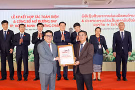 Tổng giám đốc Vietjet Đinh Việt Phương (trái) nhận Chứng nhận mở đường bay TP.HCM-Vientiane từ Phó Tổng Cục trưởng Cục Hàng không Dân dụng Lào Bounteng Symoon. (Ảnh: Doãn Tấn/TTXVN)