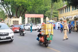 Cảnh sát giao thông phân luồng phương tiện trước cổng Trường Trung học Phổ thông Chu Văn An. (Ảnh: Hoài Nam/Vietnam+)