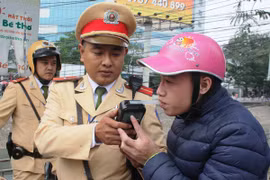 Cảnh sát giao thông tiến hành đo nồng độ cồn của người điều khiển phương tiện. (Ảnh: Việt Hùng/Vietnam+)