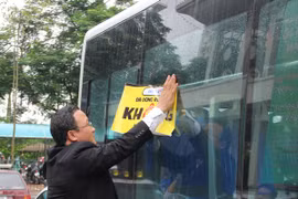 Dán khẩu hiệu "Đã uống rượu, bia không lái xe" trên xe buýt. (Ảnh: Việt Hùng/Vietnam+)