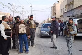 Các tay súng vũ trang và binh sỹ Iraq đứng bảo vệ tại một đường phố ở thành phố Ramadi của Iraq. (Nguồn: AFP)